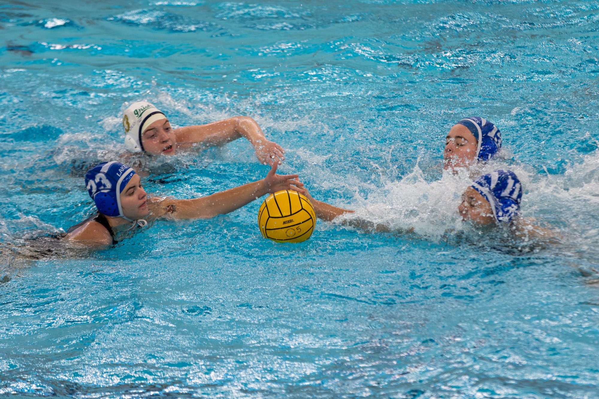 4 players race to the ball in the water